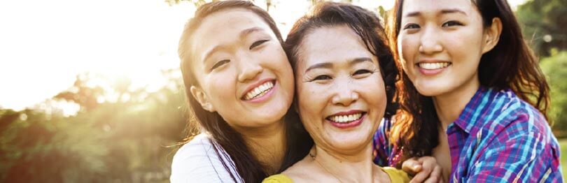Mother smiles with her two teenage daughters