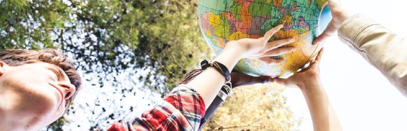 Teen holding up globe