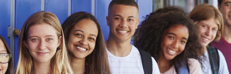 Group of teens standing in front of school lockers