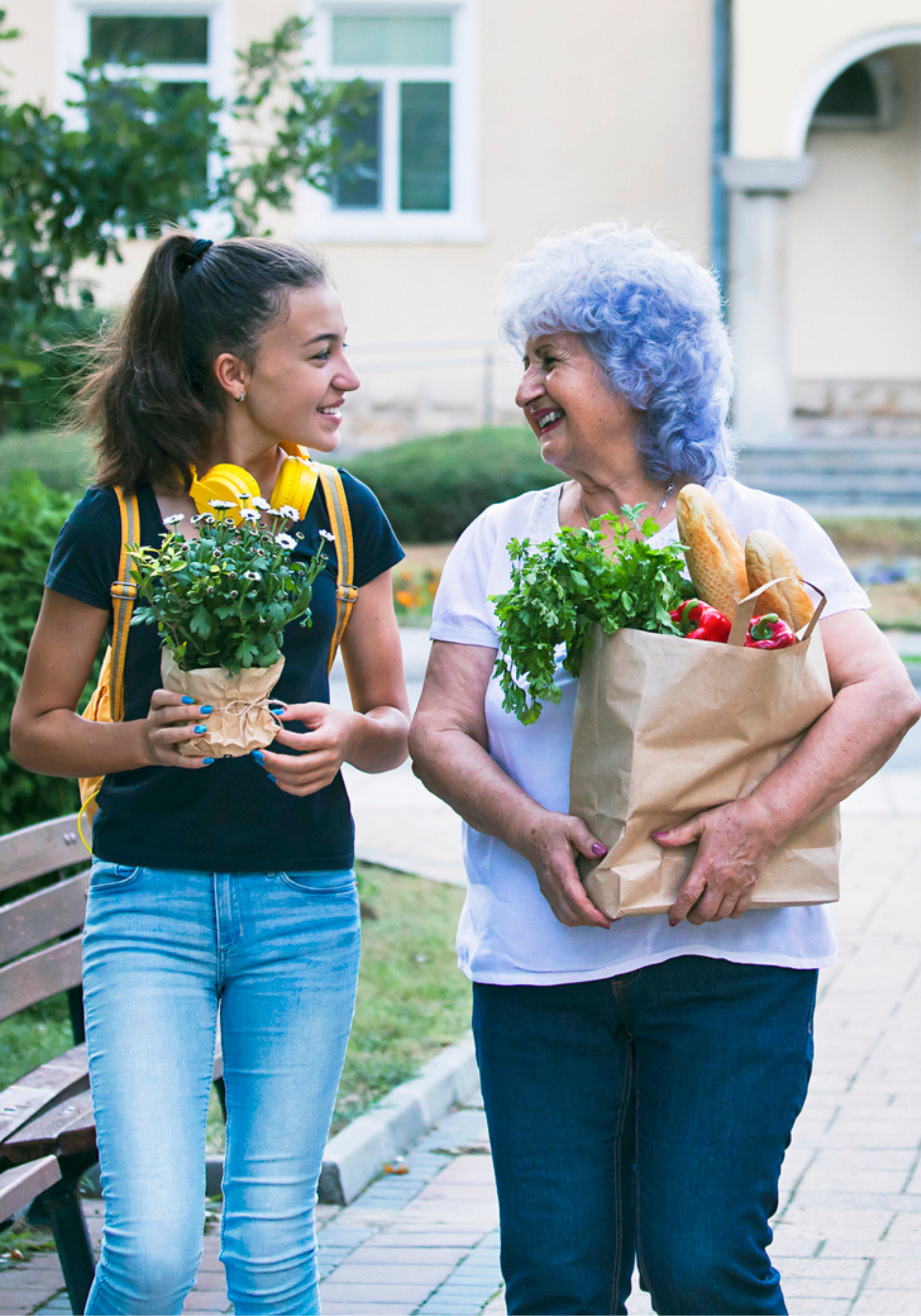 Adolescent helps an elderly woman carry her groceries